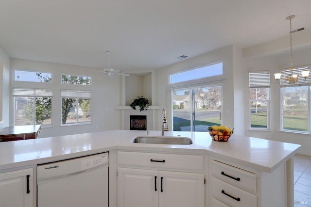 kitchen featuring white cabinetry, white dishwasher, ceiling fan with notable chandelier, and sink