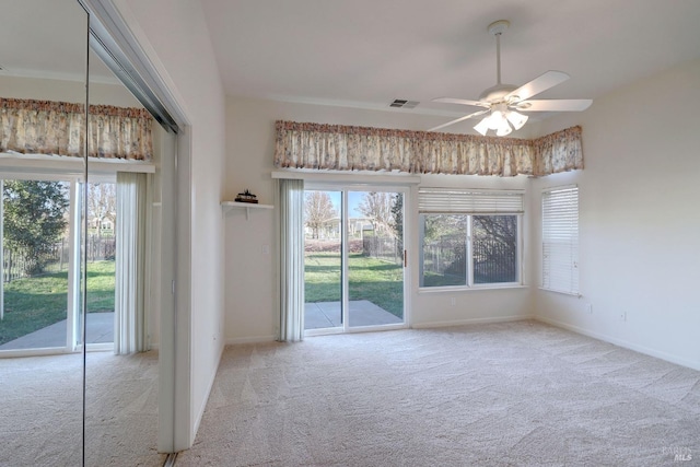 interior space with plenty of natural light, a ceiling fan, and carpet floors
