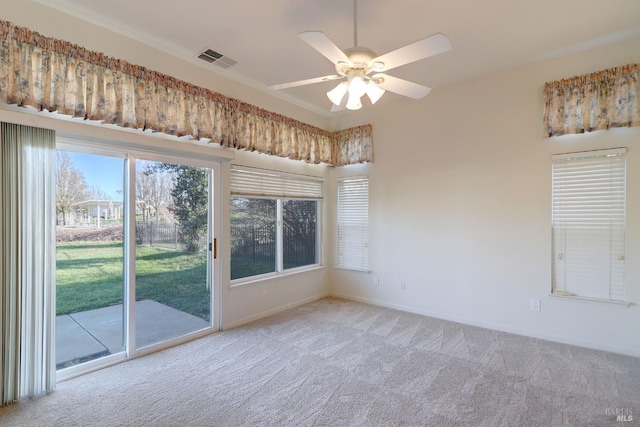 spare room with carpet floors, visible vents, a ceiling fan, and baseboards