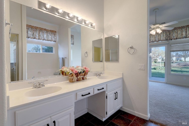 full bath with double vanity, plenty of natural light, ceiling fan, and a sink