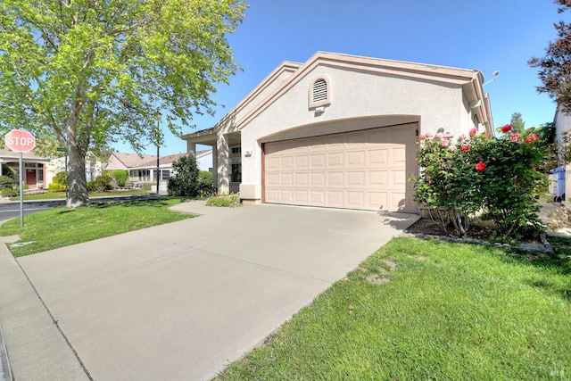 view of front of home featuring stucco siding, concrete driveway, a front yard, and a garage