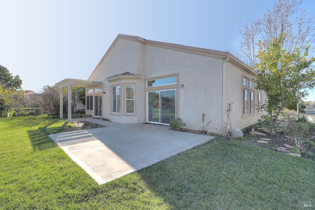 back of house featuring a patio area, a lawn, stucco siding, and fence