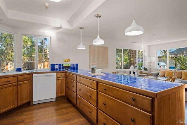 kitchen featuring pendant lighting, brown cabinets, dishwasher, and a peninsula