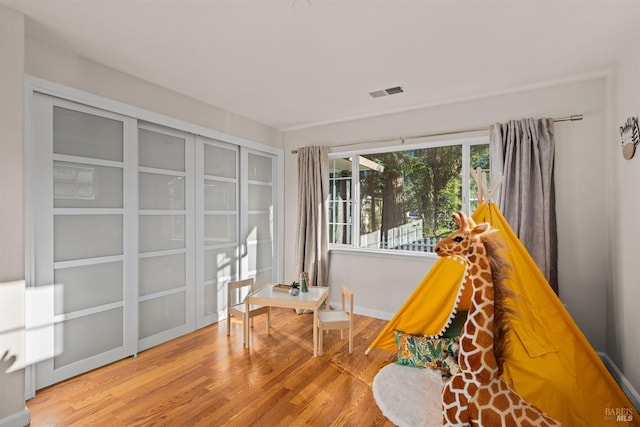 living area with light wood-style floors, baseboards, and visible vents