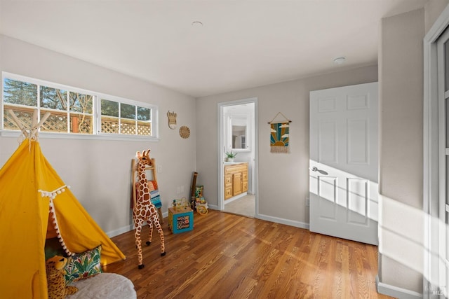 rec room with baseboards and wood finished floors