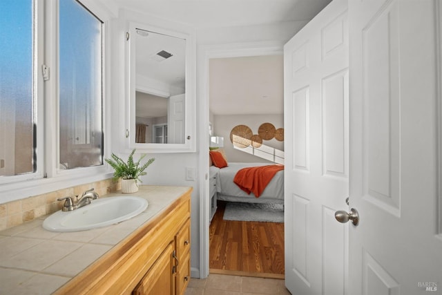 ensuite bathroom featuring tile patterned flooring, vanity, visible vents, and ensuite bathroom