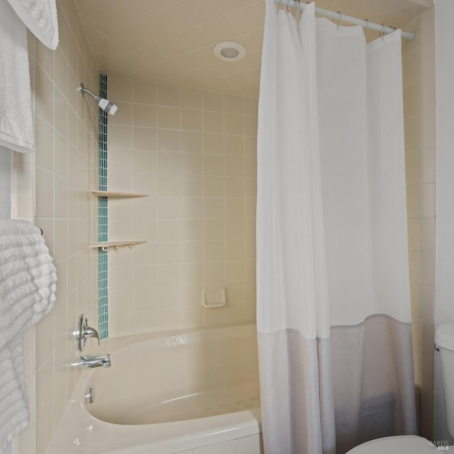 bathroom featuring toilet and shower / bath combination with curtain