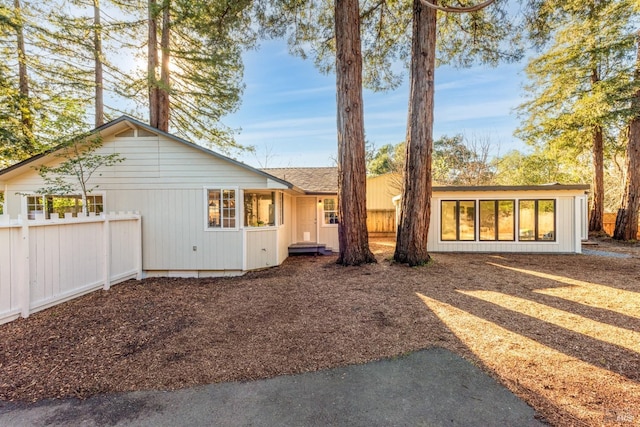 rear view of house featuring fence