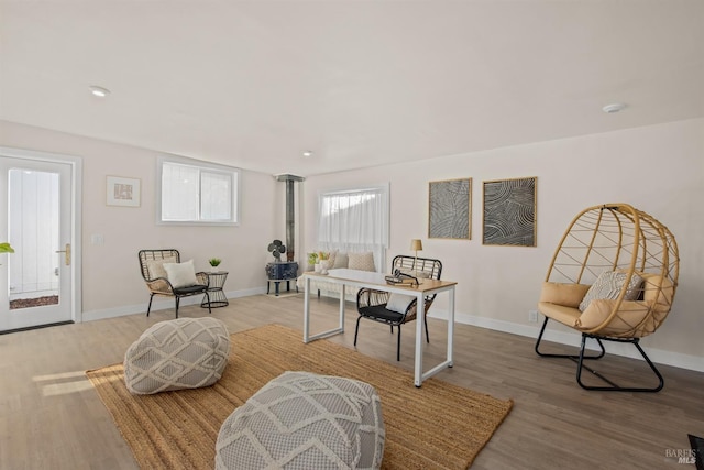 living area with baseboards and wood finished floors