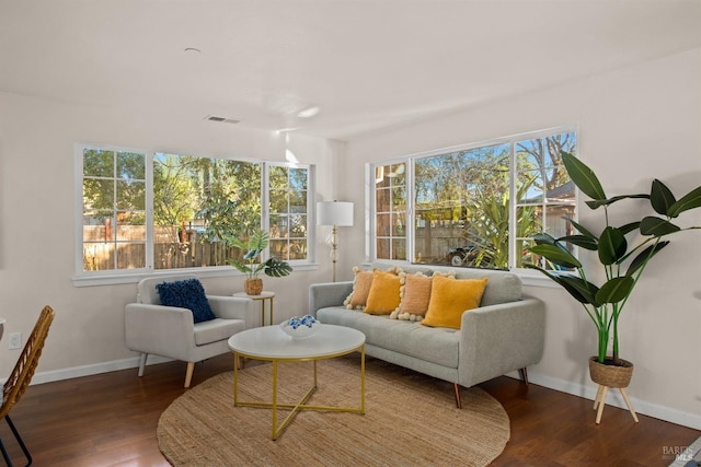 living area featuring baseboards, plenty of natural light, visible vents, and dark wood-style flooring