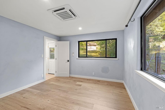 spare room with visible vents, light wood-style flooring, and baseboards