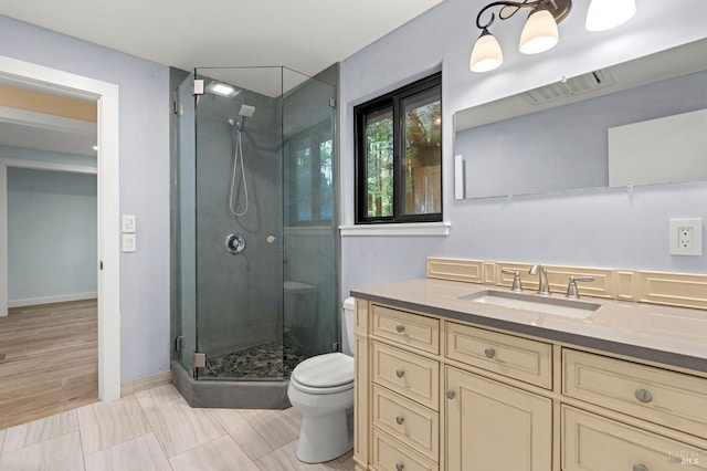 full bath with visible vents, toilet, a shower stall, vanity, and baseboards