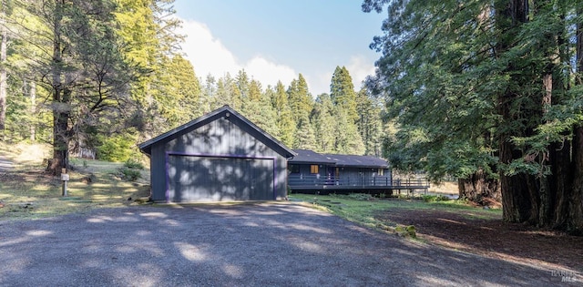 view of front of property featuring an attached garage and gravel driveway