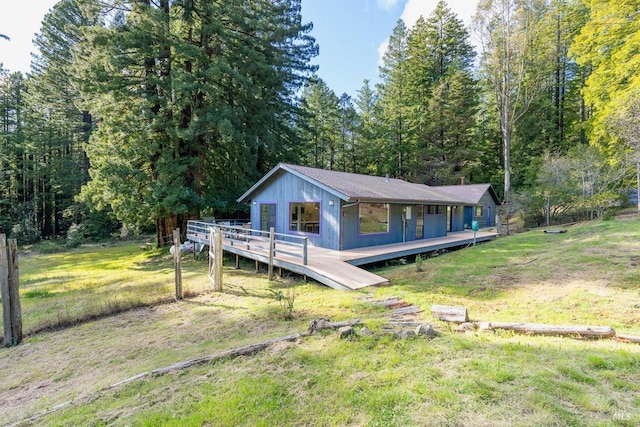 view of front of property with a wooden deck and a front yard