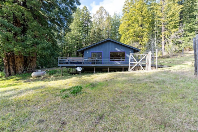 back of house with a lawn and a wooden deck