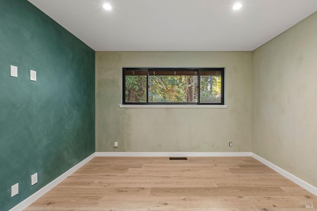 spare room with light wood-style flooring, visible vents, baseboards, and recessed lighting