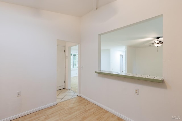 empty room with ceiling fan and light hardwood / wood-style floors