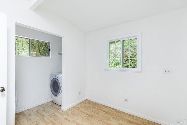 clothes washing area with washer / clothes dryer and light hardwood / wood-style floors