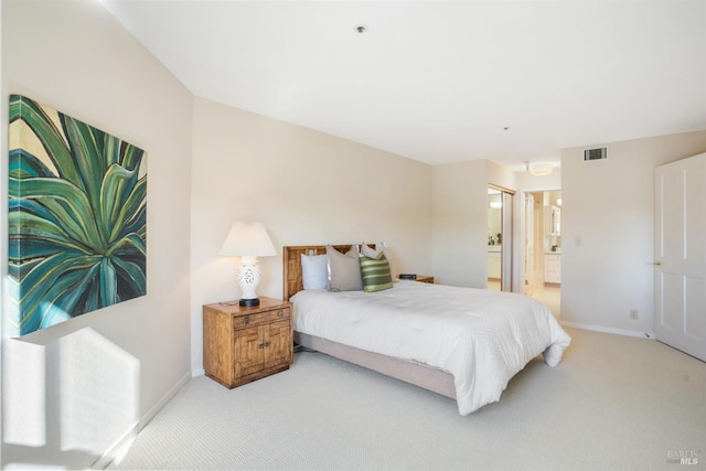 bedroom with connected bathroom and carpet floors