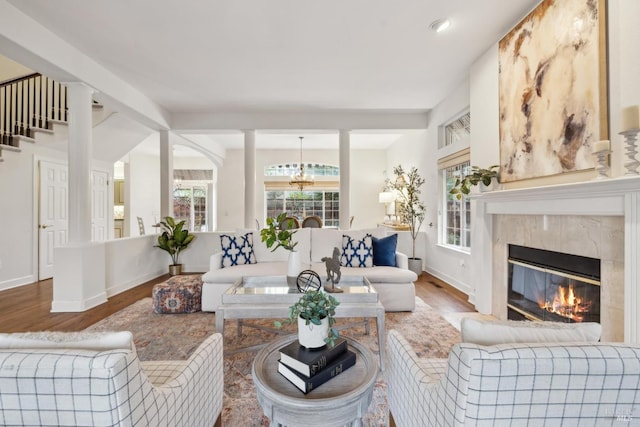 living room with a notable chandelier, hardwood / wood-style flooring, and a premium fireplace