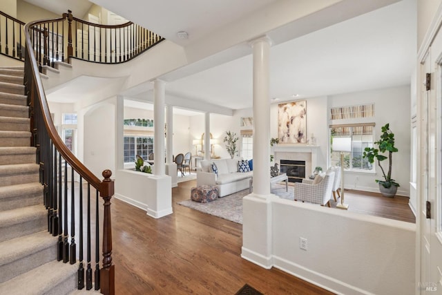 interior space featuring ornate columns, plenty of natural light, and dark hardwood / wood-style flooring