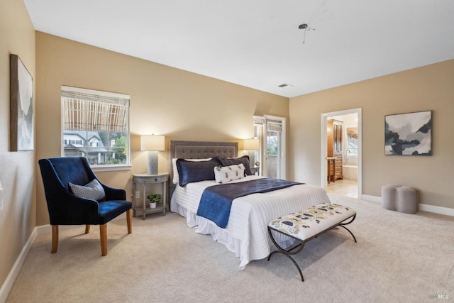 bedroom featuring ensuite bath and light colored carpet