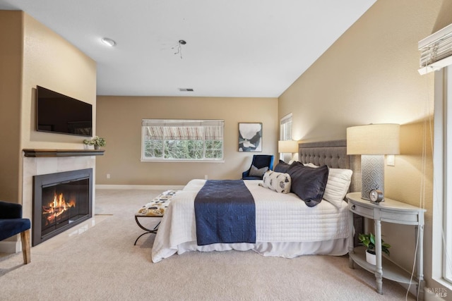 carpeted bedroom with a tiled fireplace