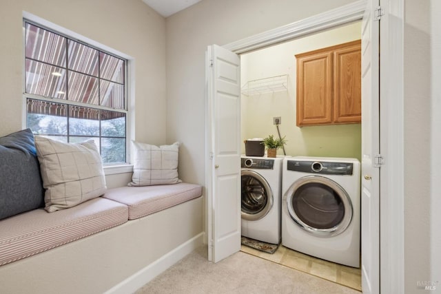 laundry room with cabinets, washer and clothes dryer, and light colored carpet