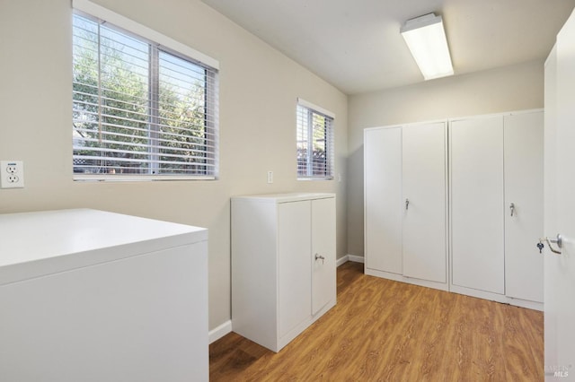 laundry area with washer / dryer and light hardwood / wood-style floors