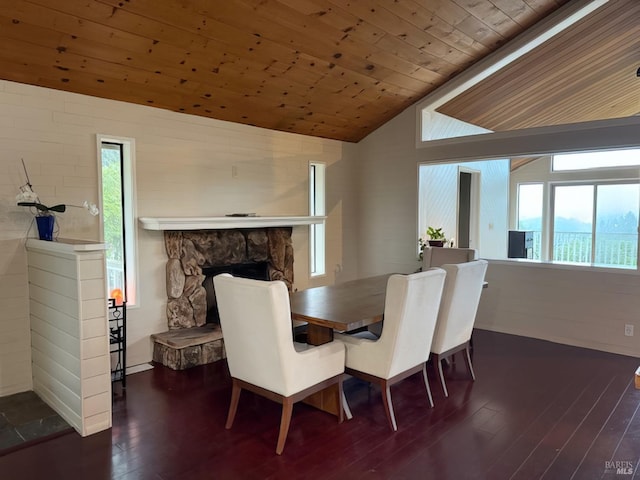 dining room with lofted ceiling, hardwood / wood-style flooring, wood ceiling, and a fireplace