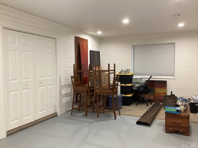 office area with wood walls, recessed lighting, and finished concrete floors