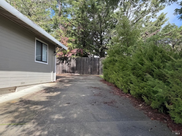 view of side of property with crawl space and fence