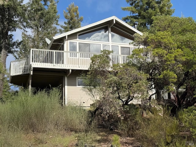 rear view of house featuring a wooden deck