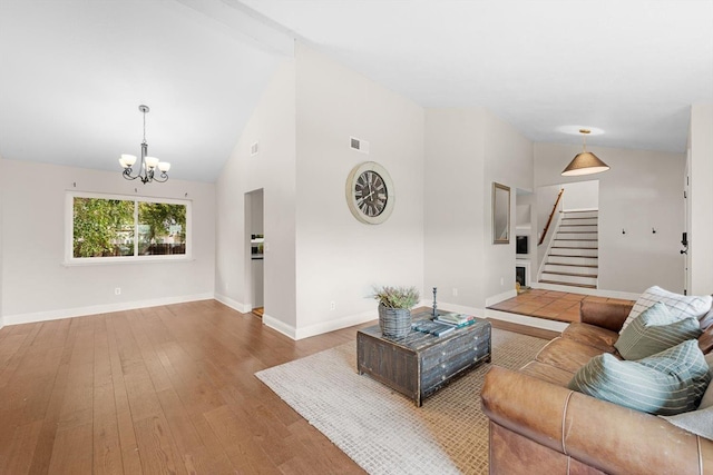 living room featuring stairway, wood-type flooring, visible vents, and baseboards