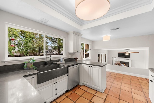 kitchen with visible vents, stainless steel dishwasher, a sink, a peninsula, and a lit fireplace