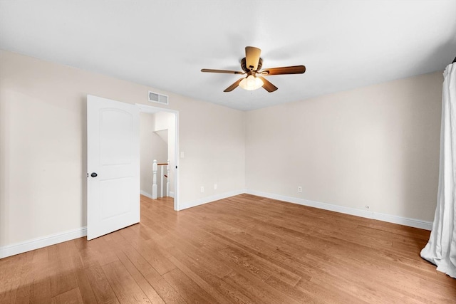 empty room with visible vents, ceiling fan, light wood-style flooring, and baseboards