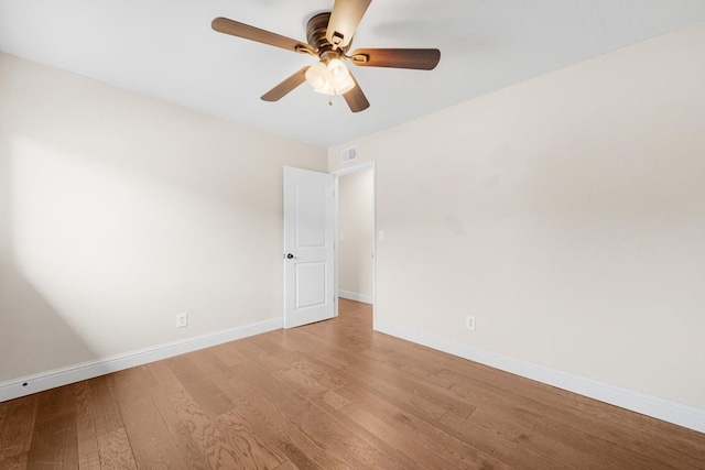 empty room with light wood-style floors, visible vents, baseboards, and a ceiling fan