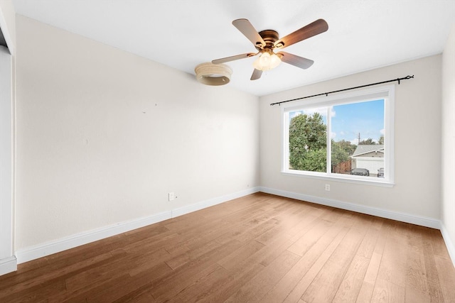 spare room with a ceiling fan, baseboards, and wood finished floors