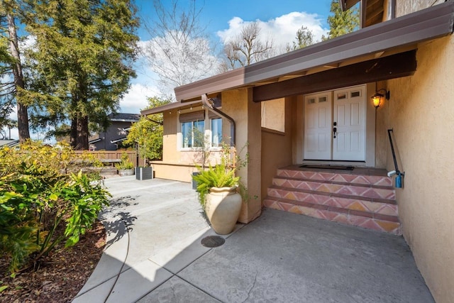 doorway to property featuring a patio area and stucco siding