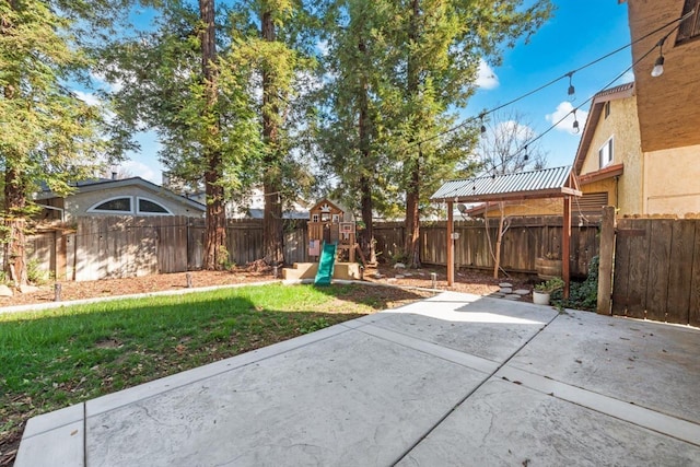 view of yard featuring a playground, a patio, and a fenced backyard