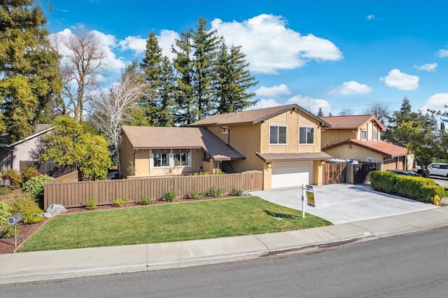 view of front facade featuring a garage, driveway, a fenced front yard, and stucco siding