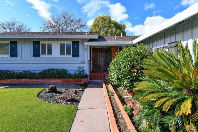 entrance to property with a lawn