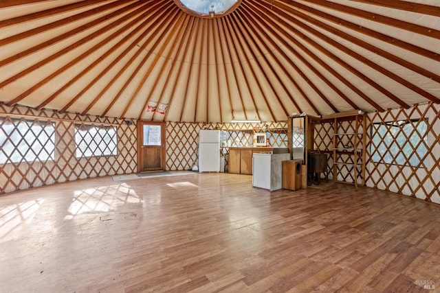 unfurnished living room featuring light hardwood / wood-style floors and vaulted ceiling