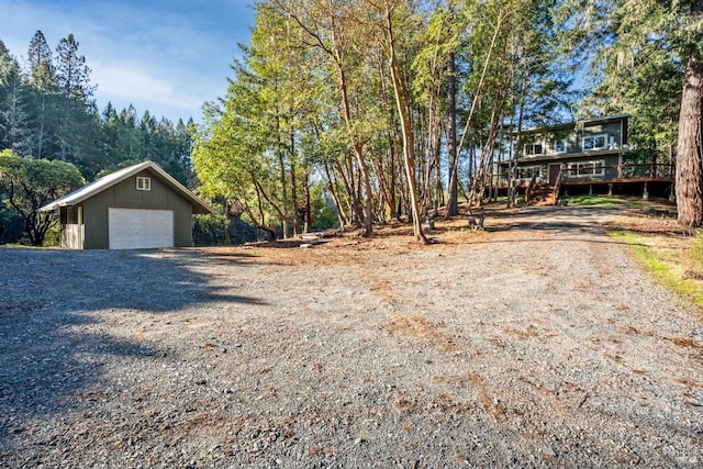 view of front facade featuring an outbuilding, a garage, and a deck