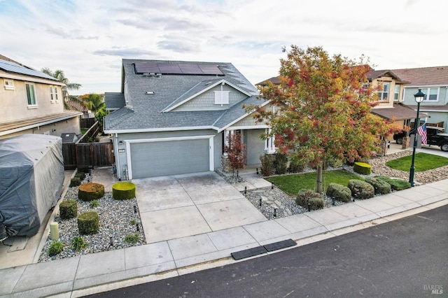 view of front of property featuring a garage and solar panels