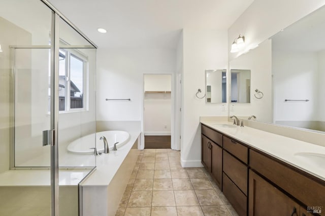 bathroom with tile patterned flooring, plus walk in shower, and vanity