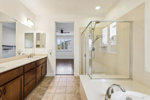 bathroom with ceiling fan, vanity, plus walk in shower, and tile patterned flooring