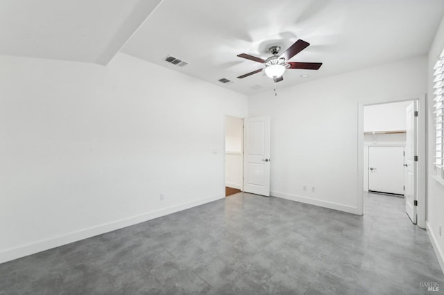 unfurnished bedroom with ceiling fan, a walk in closet, concrete flooring, and a closet