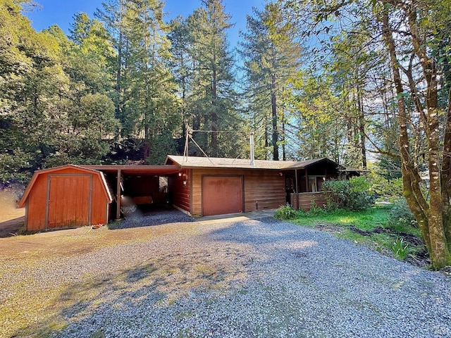 exterior space featuring a carport, driveway, and a storage shed