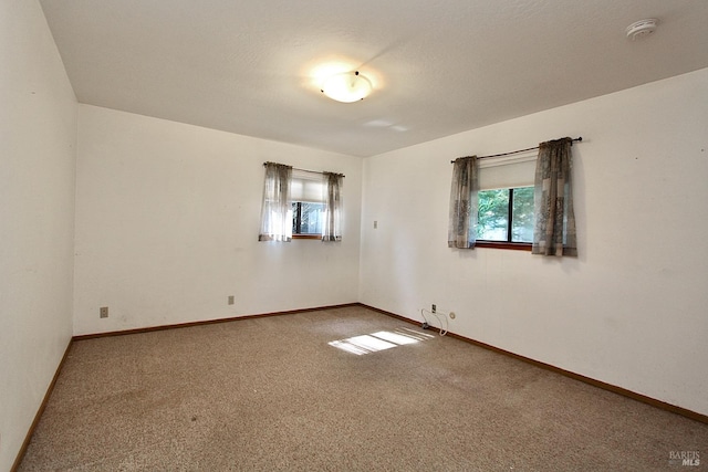 spare room with carpet and baseboards